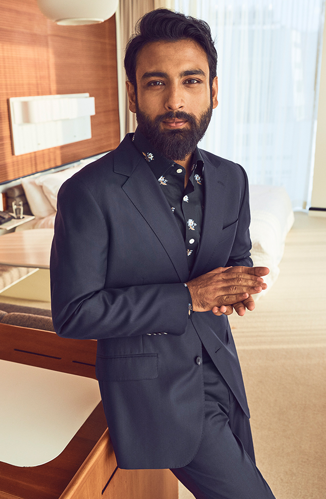 Tirthak sitting in a hotel room wearing a Bonobos suit