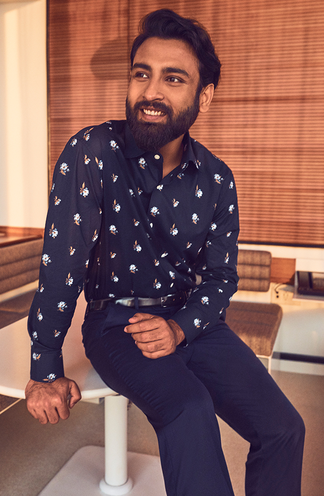 Tirthak sitting in a hotel room wearing a Bonobos suit