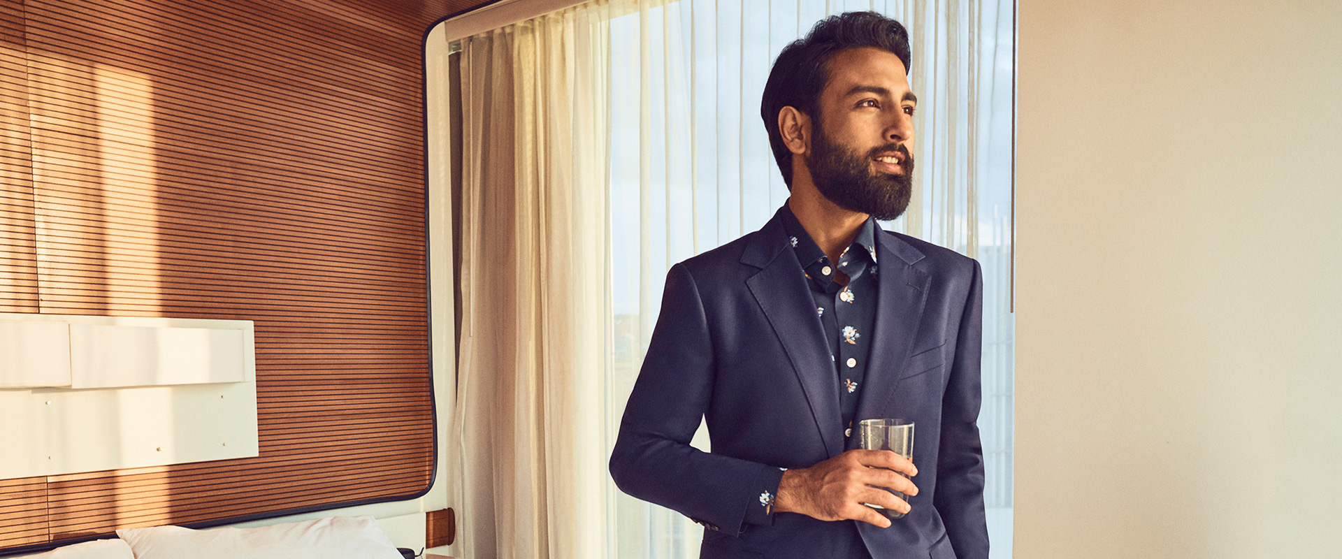 Tirthak standing in a hotel room wearing a Bonobos suit